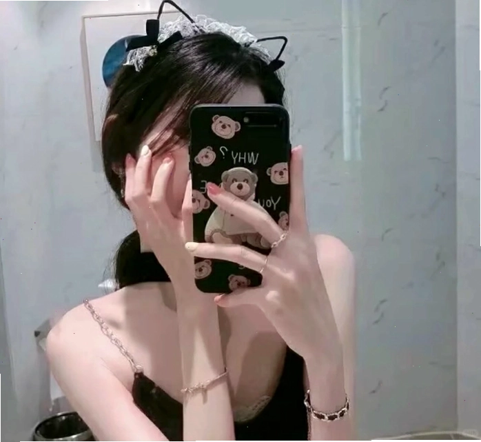 Cô gái sử dụng điện thoại để che mặt khi chụp ảnh trước gương